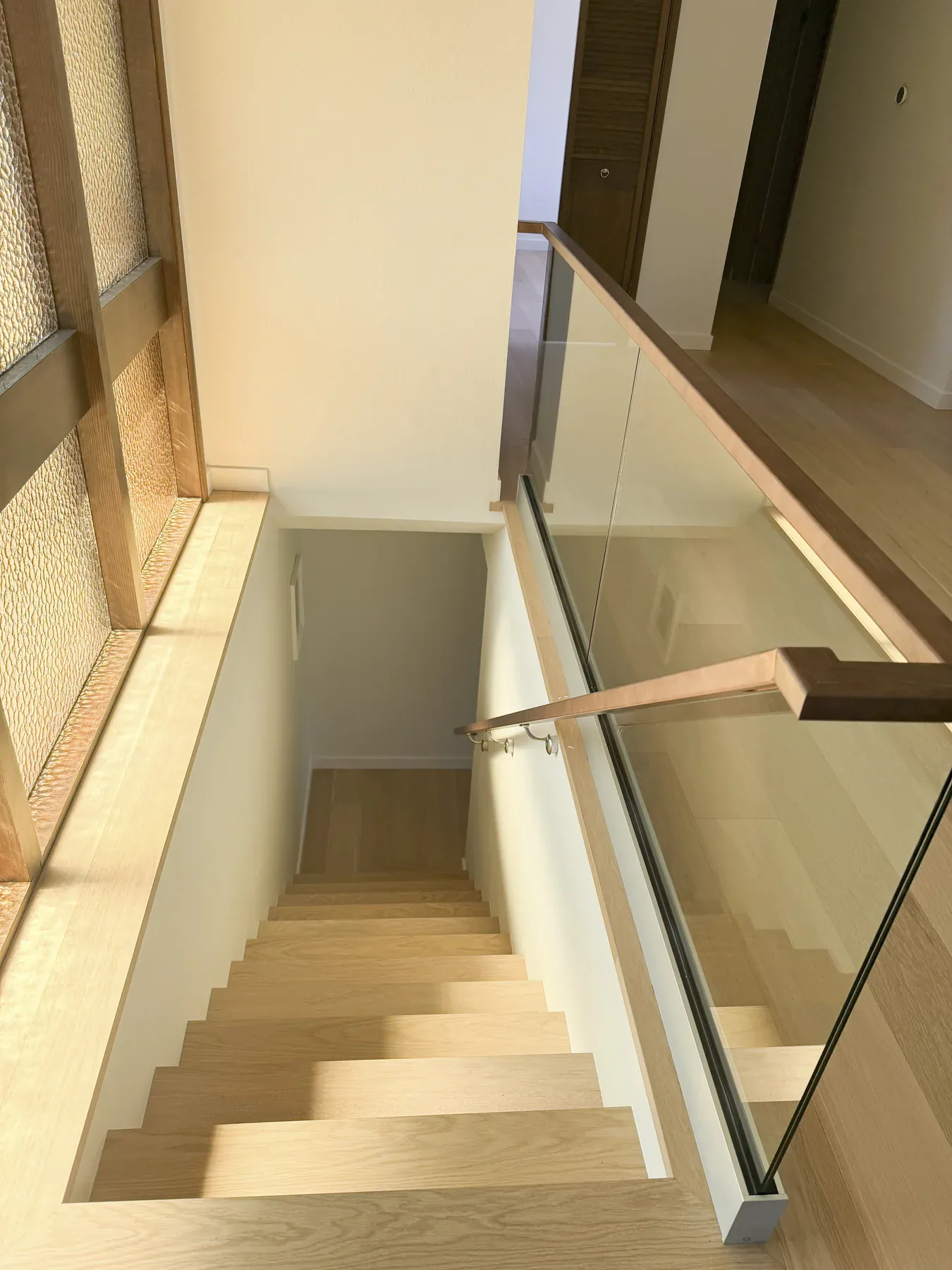 Custom staircase with oak treads and a glass balustrade after the Bellevue remodel