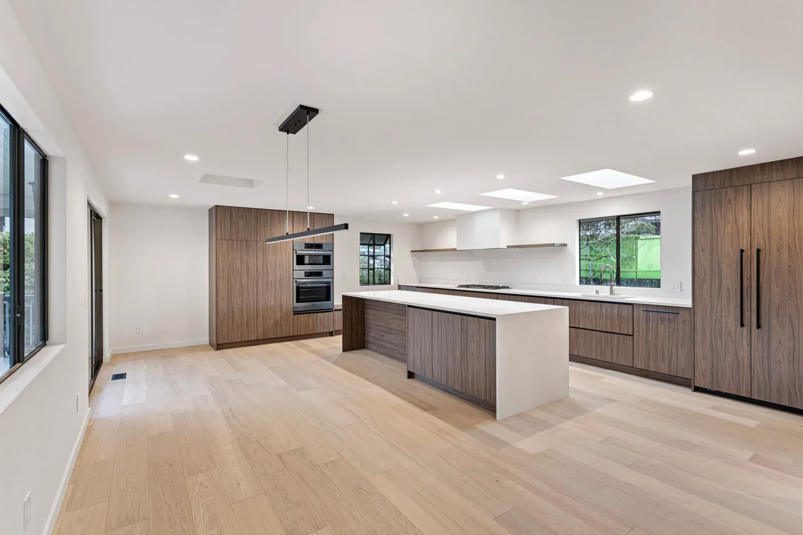 Finished Bellevue kitchen with skylights, waterfall island, and wood cabinetry