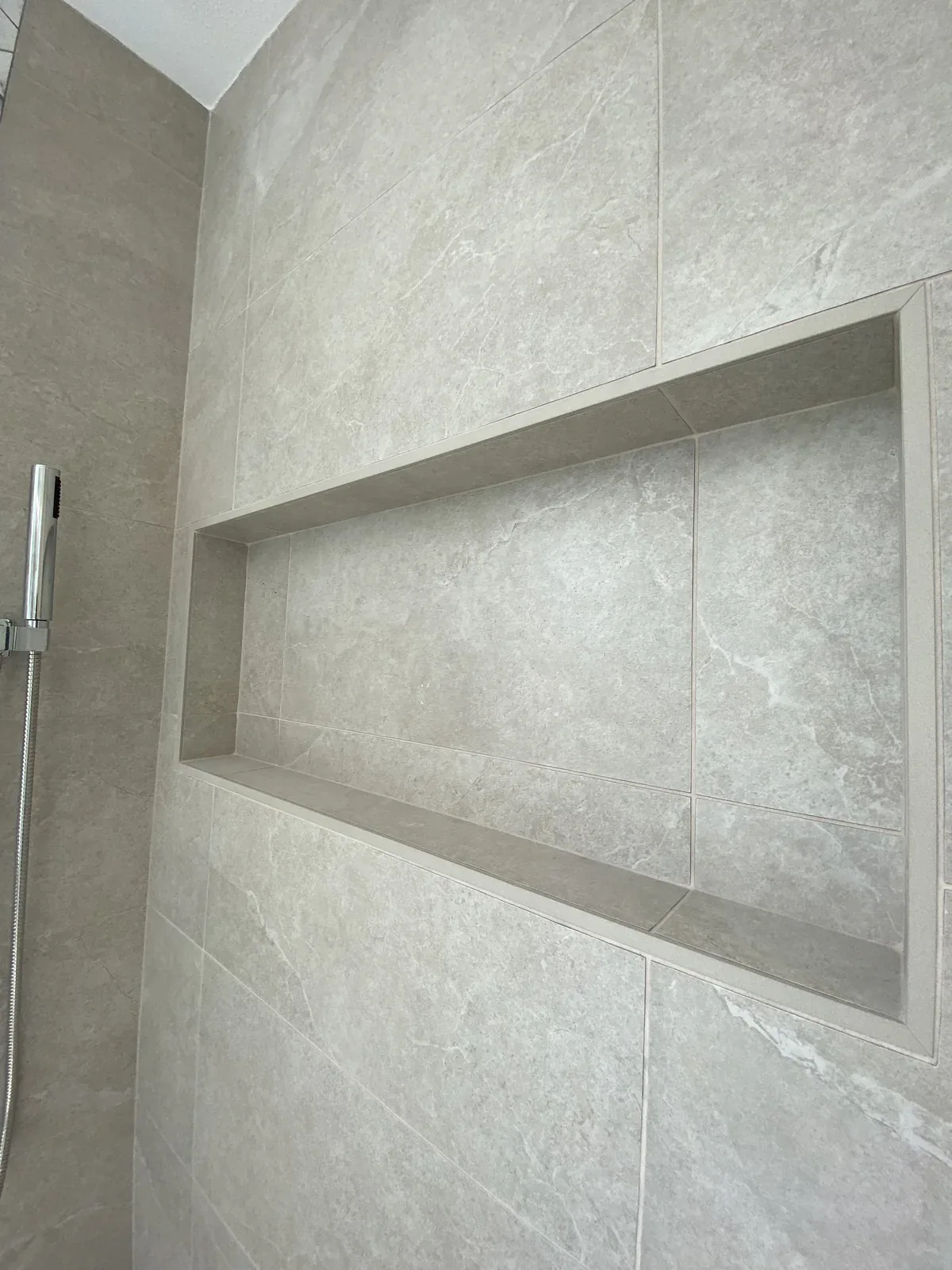 Recessed shower niche in the completed Primary Bathroom