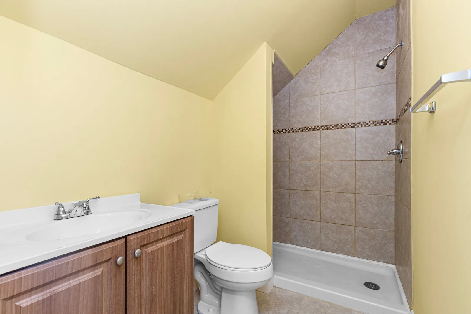 Before: Dated Kirkland bathroom with yellow tile and builder-grade fixtures