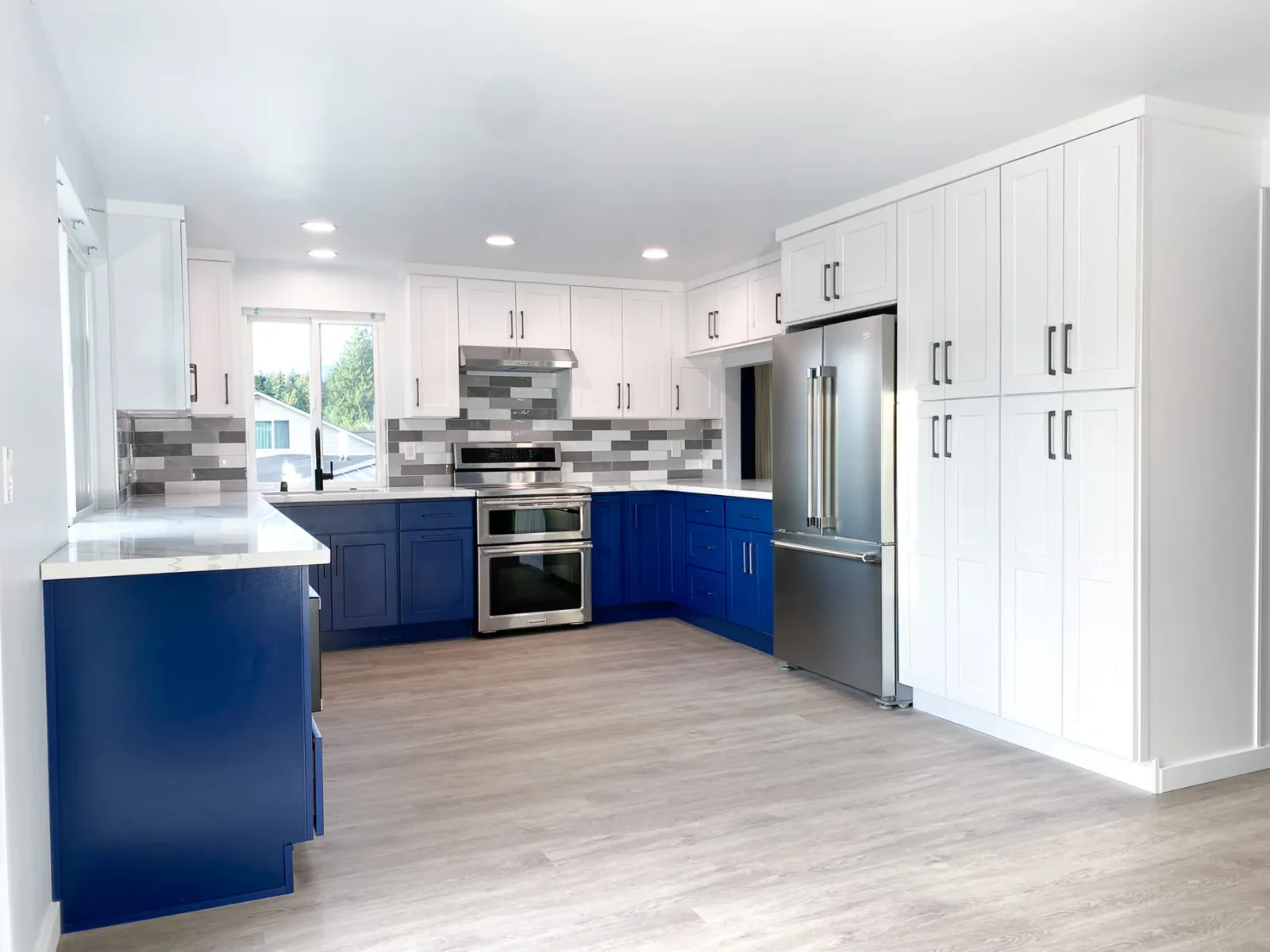 Final Kirkland kitchen with two-tone cabinetry and full-height pantry storage