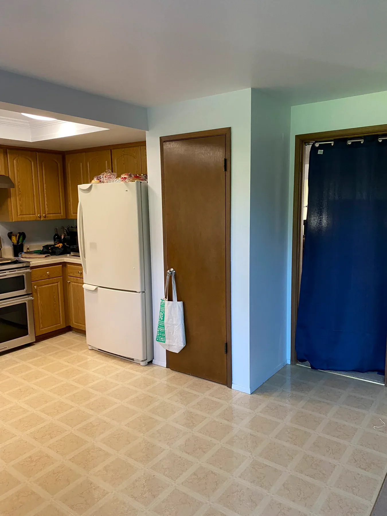 Old refrigerator, pantry, and doorway area before remodeling