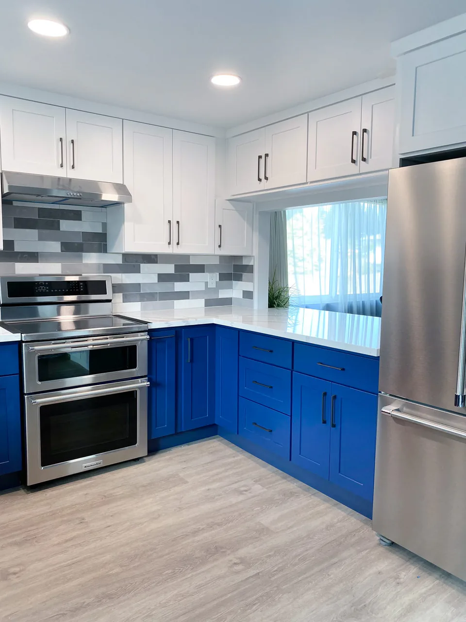 Kirkland kitchen remodel after with two-tone blue and white cabinets by Luxe Remodeling